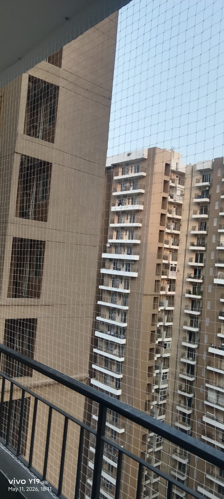 Precision-anchored transparent bird netting mesh preserving clear view from 15th floor balcony